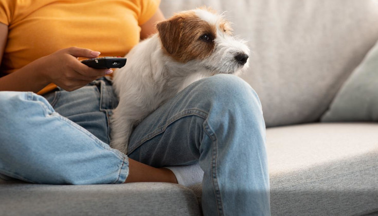 woman sitting on couch with remote